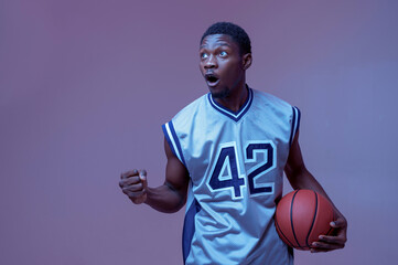 Confident basketball player poses with ball