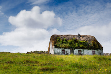 Old country house in a field on a warm sunny day, blue sky. Inishmore, Aran Islands, County Galway,...