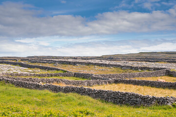 Maze of dry stone fences on Inishmore, Aran Islands, County Galway, Ireland. Irish landscape. Warm sunny day, cloudy sky
