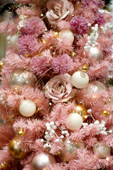 Obraz na płótnie Canvas Christmas background. Pink Christmas tree branches with balls and flowers in monochrome and pastel colors, selective focus