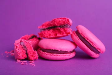 Foto op Plexiglas Macarons Delicious pink macarons on purple background, closeup