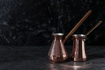 Beautiful copper turkish coffee pots on grey table. Space for text
