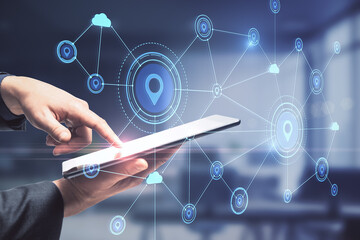 Hand in office pointing at tablet with creative glowing digital map with location pins on blurry background. Double exposure.