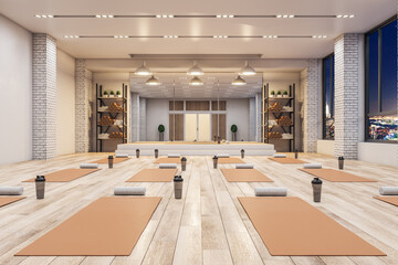 Modern concrete yoga gym interior with equipment, night city view and wooden flooring. Healthy...