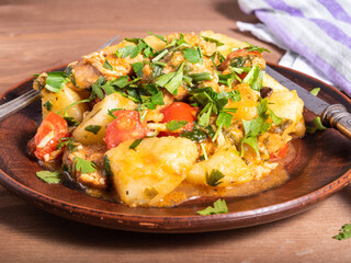 Homemade stew with potatoes, chicken and parsley vegetables on a plate close-up - rustic healthy food