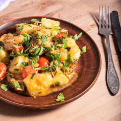 Homemade stew with potatoes, chicken and parsley vegetables on a plate close-up - rustic healthy food