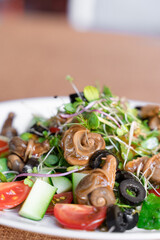 Salad with snail, olive, tomatoe cherie, cucumber and greens