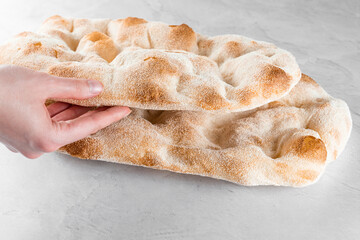 Touching and checking quality dough for pinsa romana on light background. Gourmet italian cuisine. - obrazy, fototapety, plakaty