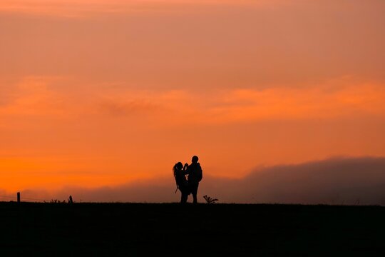 silhouette of a couple trekking in the mountian with a sunset