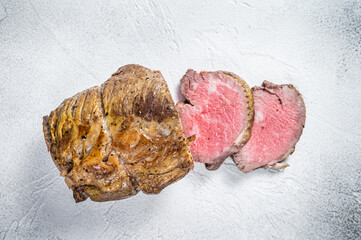 Roast beef meat fillet on kitchen table. White background. Top view