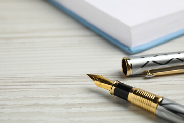 Beautiful fountain pen with ornate nib on white wooden table, closeup. Space for text