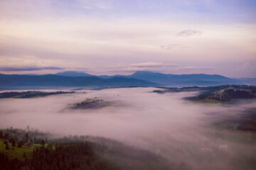 Dawn fog covers the lowlands between the mountains