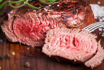 medium roast rib-eye steak on wooden background