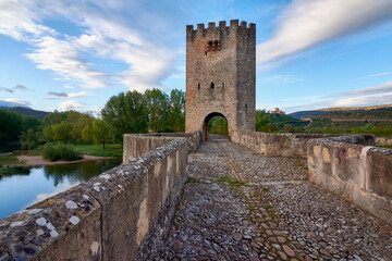 Fototapeta na wymiar medieval bridge at sunrise with castle in the background