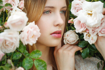 Obraz na płótnie Canvas Beautiful young woman smells a rose flower. High quality photo
