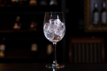 Glass with ice cubes on the bar