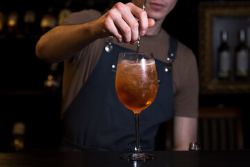 The bartender making Aperol Spritz cocktail. Bartender hands close up