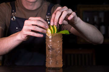 Close up bartender hands making zombie cocktail in nightclub