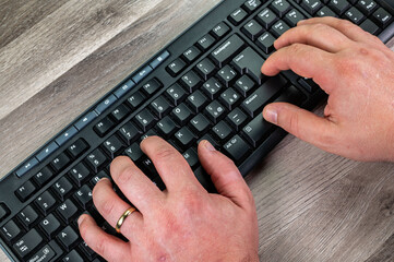 hands of a man typing on the pc keyboard