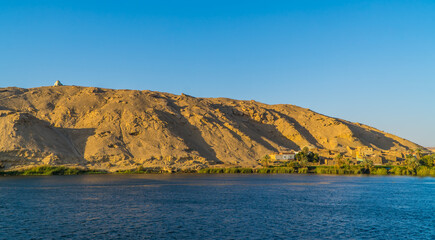 Panoramic view of a traditional town on the Nile River near Luxor, Egypt with mountainous...