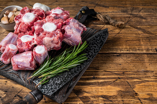 Raw beef Oxtail cut Meat on wooden cutting board with knife. wooden background. Top view. Copy space