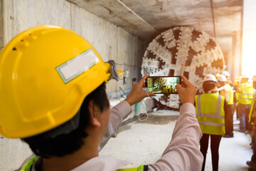 Engineer wear yellow helmet take a photo,Technician control underground tunnel construction at...