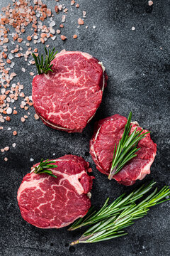Fillet Mignon tenderloin raw meat beef steaks on butchery table. Black background. Top view