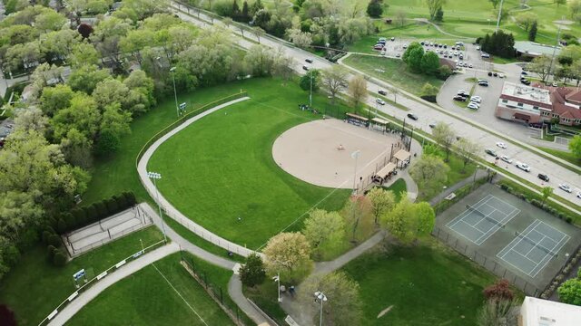 Aerial Drone view of kids play Baseball Field at Park on Sunny Day. Wide top view