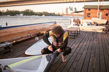 Fototapeta premium Windsurfer surfing on a windy day at the river.
