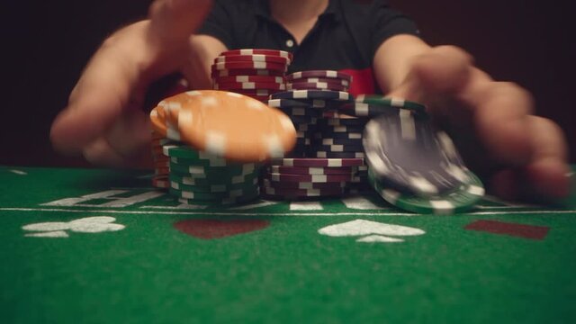 Male player betting all chips in while playing in casino, close up