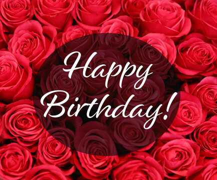 Happy Birthday! Beautiful red roses as background, top view