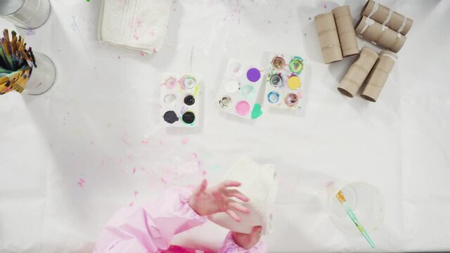 Flat lay. Kids papercraft. Painting empty toilet paper rolls with acrylic paint to create paper bugs.