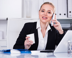 Young businesswoman having phone call conversation at workplace in office