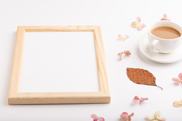 Obraz na płótnie Canvas Composition with wooden frame, brown beech autumn leaves, hydrangea flowers and cup of coffee. mockup on white background. side view, copy space.