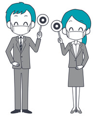 マスクを着けて正解の札を持つスーツ姿の男女