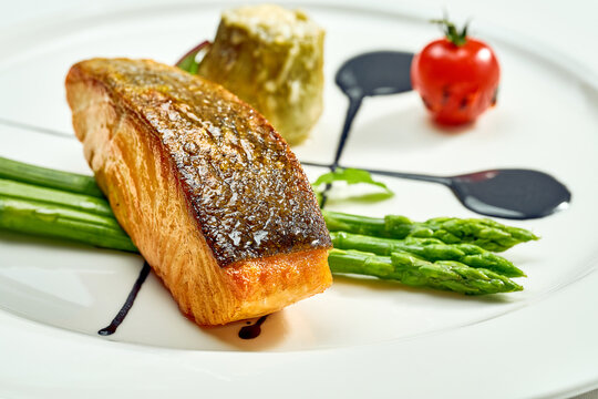 Grilled Salmon Steak With Asparagus And Balsamic Sauce In A White Plate. Isolated On White Background. View From Above