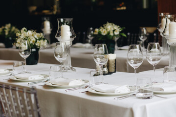 tableware Glasses, flower fork, knife served for dinner in restaurant with cozy interior