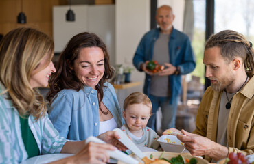 Happy multigeneration family indoors at home eating healthy lunch.