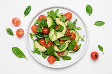 Spinach avocado tomatoes salad. Healthy vegan food. White background, top view, copy space