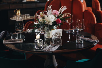 tableware Glasses, flower fork, knife served for dinner in restaurant with cozy interior