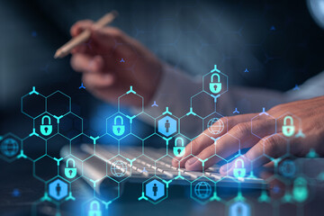 A programmer is typing a code on computer to protect a cyber security from hacker attacks and save clients confidential data. Padlock Hologram icons over the typing hands. Formal wear.