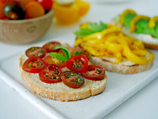 Vegan bruschetta. Delicious bruschetta with tomatoes, yellow peppers and avocado on a white plate. Appetizing Vegetable Snack Cheese Sandwiches