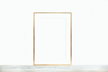 Thin gold frame with passepartout on a wooden table