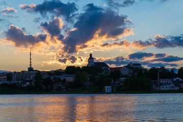 Town sea coast at the sunset.Sun rays passing through storm clouds over the lake bay town. Urban image.