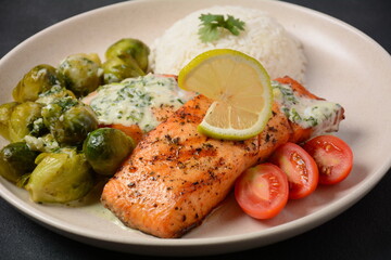 Fried salmon steaks. Cooked salmon steak with pepper, herbs, lemon, garlic, olive oil and Brussels sprouts. Grilled fresh fish.