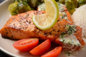 Fried salmon steaks. Cooked salmon steak with pepper, herbs, lemon, garlic, olive oil and Brussels sprouts. Grilled fresh fish.