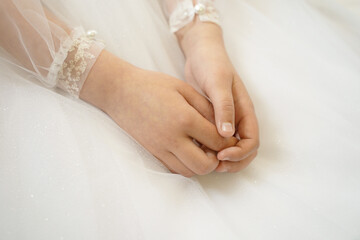 tender hands of a girl on a light dress during confession in the church