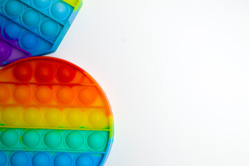 Trendy popular toy anti-stress POP it. Celicon rainbow toy for the development of children's motor skills on a pink background