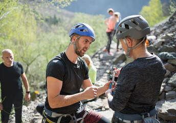 Naklejka premium Group of seniors with instructor climbing rocks outdoors in nature, active lifestyle.