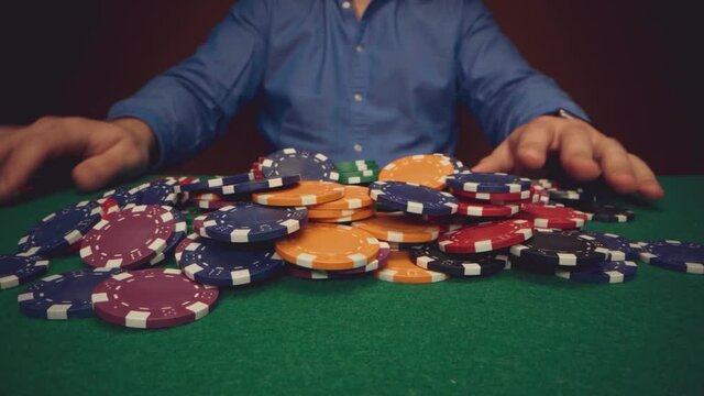 Male player betting all chips in while playing in casino, close up
